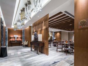 um restaurante com mesas e cadeiras e um lustre em Pullman Taiyuan em Taiyuan