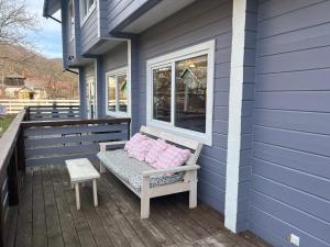 een bankje op de veranda van een huis bij Кольорове життя in Mykulychyn
