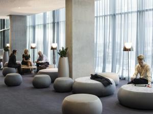 a group of people sitting in a lobby with chairs and tables at Pullman Liverpool in Liverpool