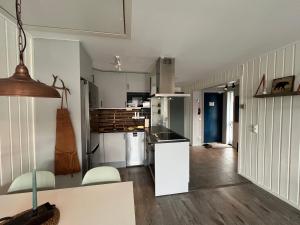 a kitchen with white walls and wooden floors at Åre Stay- Åregårdarna 426 in Åre
