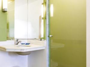 a bathroom with a sink and a mirror at ibis budget Sertaozinho in Sertãozinho