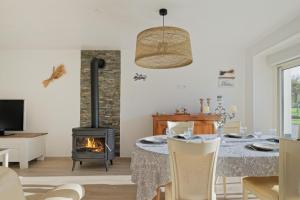 a living room with a table and a fireplace at Gite en Brocéliande avec vue in Néant-sur-Yvel