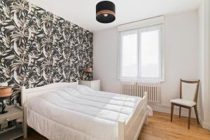 a bedroom with a white bed and a black and white wallpaper at Gite en Brocéliande avec vue in Néant-sur-Yvel