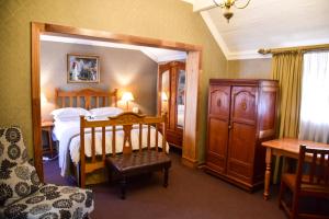 a bedroom with a bed and a large mirror at Hobbit Boutique Hotel in Bloemfontein