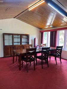 a dining room with a wooden table and chairs at The Groot in Ooty