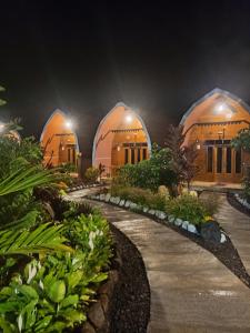 a row of three domes in a garden at night at Indah Damai Cottages in Sidomukti