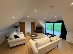 a living room with two couches and a table at The Silvan Lodge, Peace, Privacy, and Pure calm 