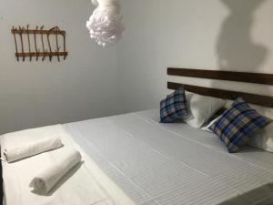 a bed with blue and white pillows in a bedroom at A4 Villa Safari Cottage in Udawalawe +51 photos