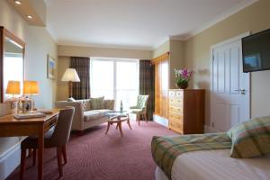 a hotel room with a bed and a desk and a room at Carnoustie Golf Hotel 'A Bespoke Hotel’ in Carnoustie