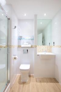 uma casa de banho com um WC, um lavatório e um chuveiro em Carnoustie Golf Hotel 'A Bespoke Hotel’ em Carnoustie