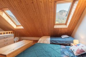 a attic bedroom with two beds and a window at Gîte Centre Luz-Saint-Sauveur in Luz-Saint-Sauveur