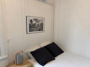 康布雷Studio Tout équipé à Cambrai的一间小卧室,配有一张床和墙上的照片