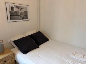 康布雷Studio Tout équipé à Cambrai的墙上有照片的一张小床 更多3张照片