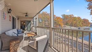 a porch with a table and chairs and a view of the water at Lakeside Haven - Condo for 8 in Sunrise Beach