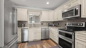 a kitchen with white cabinets and stainless steel appliances at Lakeside Haven - Condo for 8 in Sunrise Beach