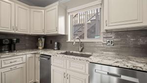 a kitchen with white cabinets and a sink and a window at Lakeside Haven - Condo for 8 in Sunrise Beach
