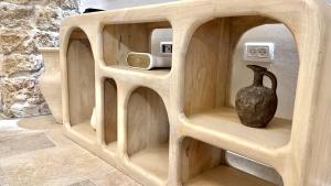 a wooden shelf with a vase sitting on it at Knight House Akko in ‘Akko