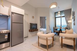 a living room with a kitchen and a dining room at Bright 1BR with Balcony the Gate, Masdar City in Abu Dhabi
