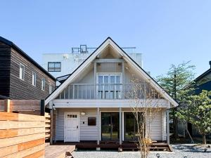 a white house with a gambrel roof at yado suzuka 1 in Suzuka