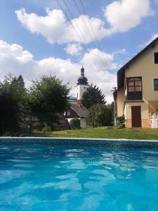 a house with a lighthouse in the background with a swimming pool at Chata Salicka Bozkov in Bozkovska