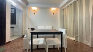 Un comedor con una mesa y sillas blancas. en Hotel Kundan Palace, en Nueva Delhi 13 fotos más