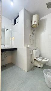 un baño con inodoro y lavabo en Hotel Kundan Palace, en Nueva Delhi