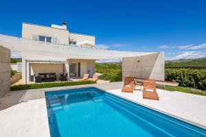 ドゥゴポイエにあるFerienhaus In Dugopolje Mit Beheiztem Poolのプールと家のあるヴィラ