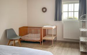 Habitación pequeña con cuna y silla en Cozy Home In Lo-Reninge With Wifi, en Lo-Reninge