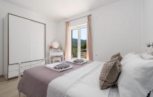 ein weißes Schlafzimmer mit einem Bett und einem großen Fenster in der Unterkunft Holiday home Silvija by Villas Guide in Primorski Dolac + 27 Fotos