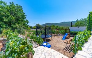 ein Garten mit Spielplatz und einigen Pflanzen in der Unterkunft Holiday home Silvija by Villas Guide in Primorski Dolac