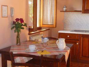 a kitchen with a table with a vase of flowers at Magnolia in Pratovecchio