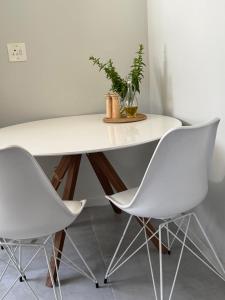 a white table and two white chairs in a room at De Eike in Stellenbosch