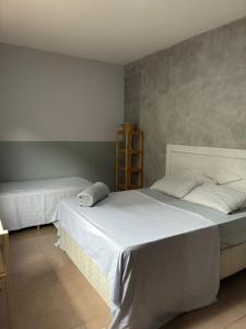 - 2 lits dans une chambre avec des draps blancs dans l'établissement Suite familia - Centro de Itu, à Itu