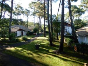 a view of a yard with houses and trees at T3 Duplex avec Piscine, Tennis, Parking et Terrasse à Soustons - FR-1-379-78 in Soustons
