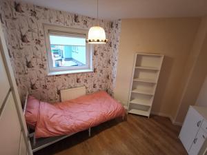 Dwa poziomy Wrocławska في بياويستوك: غرفة نوم صغيرة بها سرير ونافذة