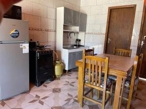 Una cocina con una mesa de madera y un refrigerador. en Las Palmeras, en Chuí