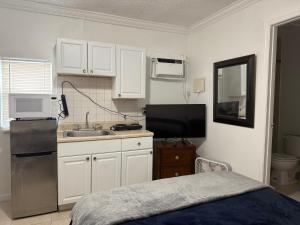 een kleine keuken met witte kasten en een spoelbak bij My Garden in Miami Florida in Palmetto Bay