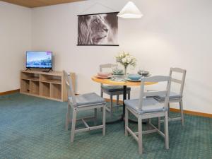 ヴェンゲンにあるApartment BeKb-Gebäude Apt 07 by Interhomeのテーブルと椅子とテレビのあるダイニングルーム