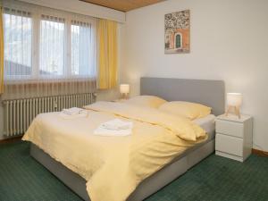 ヴェンゲンにあるApartment BeKb-Gebäude Apt 07 by Interhomeのベッドとタオル2枚のある寝室