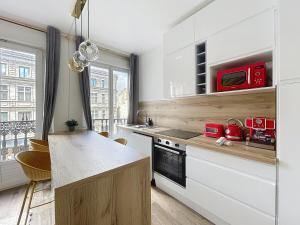 a kitchen with white cabinets and a counter top at Mariani Place to Be in St Etienne in Saint-Étienne