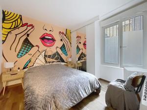 a bedroom with a wall with a painting of women at Mariani Place to Be in St Etienne in Saint-Étienne