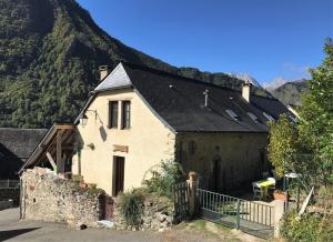 a house with a mountain in the background at Le lheze in Cette-Eygun