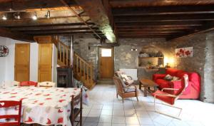 a living room with a red couch and a table at Le lheze in Cette-Eygun