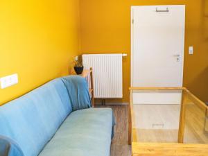 a living room with a blue couch and a white door at Apartment Schnakenberg by Interhome in Ober Ochtenhausen