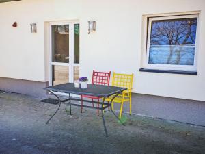 a table and two chairs sitting next to a building at Apartment Schnakenberg by Interhome in Ober Ochtenhausen