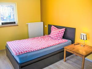 a small bedroom with a bed and a table at Apartment Schnakenberg by Interhome in Ober Ochtenhausen +9 photos