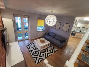 Dwa poziomy Wrocławska في بياويستوك: غرفة معيشة بها أريكة زرقاء وثريا