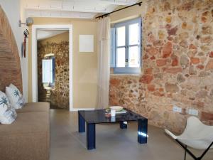un salon avec une table et un mur en pierre dans l'établissement Holiday Home Can Caritat by Interhome, à Pals 31 autres photos