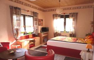 a bedroom with a bed and a desk and two windows at Blick In Die Natur in Ilmenau