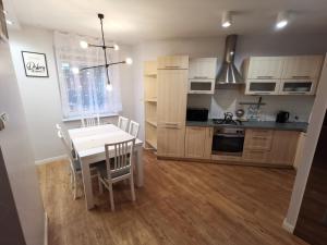 Dwa poziomy Wrocławska في بياويستوك: مطبخ وغرفة طعام مع طاولة وكراسي